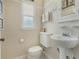 Cozy half-bathroom offers clean features and a pedestal sink with classic fixtures at 400 W Par St, Orlando, FL 32804