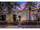 Stunning two-story home featuring a red tile roof, lush landscaping, and palm trees against a colorful sunset sky at 400 W Par St, Orlando, FL 32804