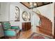 Elegant foyer featuring a curved staircase, patterned ceiling, vintage furniture, and unique arched windows at 400 W Par St, Orlando, FL 32804