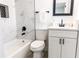 Beautiful bathroom featuring marble tiling, a modern vanity, and sleek black fixtures at 403 Louis St, Leesburg, FL 34748