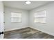 Bright bedroom with wood-look floors, large windows, and modern lighting at 403 Louis St, Leesburg, FL 34748