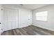 Neutral bedroom with wood-look floors, a closet, and plenty of natural light at 403 Louis St, Leesburg, FL 34748