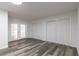 Large bonus room with sleek wood-look flooring and double doors at 403 Louis St, Leesburg, FL 34748