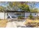 Inviting home exterior showcases covered carport, white picket fence, lush yard and a charming brick facade at 403 Louis St, Leesburg, FL 34748