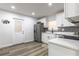 Updated kitchen featuring stainless steel appliances, white cabinetry, and a door leading to the backyard at 403 Louis St, Leesburg, FL 34748