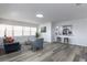 Open-concept living area with neutral paint, modern gray plank flooring, and bar with seating to the kitchen at 403 Louis St, Leesburg, FL 34748