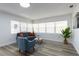 Bright living room with luxury vinyl plank flooring, large windows, and comfortable seating at 403 Louis St, Leesburg, FL 34748