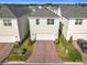 Aerial view of a home showcasing a two-car garage, brick driveway, and manicured landscaping at 431 Scotsmans Pl, Debary, FL 32713