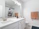 Bright bathroom featuring a double sink vanity, white cabinets, and a shower with stylish curtain at 431 Scotsmans Pl, Debary, FL 32713