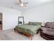 This bedroom features neutral walls, ceiling fan, carpeted floors, and a comfortable recliner at 431 Scotsmans Pl, Debary, FL 32713