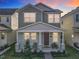 Two-story home featuring a covered front porch with chairs and table during sunset at 431 Scotsmans Pl, Debary, FL 32713