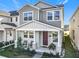 Charming two-story home with covered front porch, chairs, and nicely landscaped yard at 431 Scotsmans Pl, Debary, FL 32713