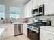 This kitchen features white cabinets, stainless steel appliances, and quartz countertops at 431 Scotsmans Pl, Debary, FL 32713