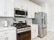 Kitchen boasts white cabinets, stainless steel appliances, and quartz countertops at 431 Scotsmans Pl, Debary, FL 32713