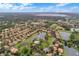 Aerial view of a neighborhood with community lakes, lush landscaping, and homes with tile roofs under a partly cloudy sky at 448 Douglas Edward Dr, Ocoee, FL 34761