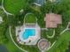 Drone shot of a community pool, bathhouse, and playground surrounded by lush greenery and walking paths at 448 Douglas Edward Dr, Ocoee, FL 34761