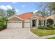 Charming single-story home featuring a red tile roof, stone accents, a three-car garage, and a welcoming front entrance at 448 Douglas Edward Dr, Ocoee, FL 34761