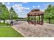 Covered lakeside gazebo featuring seating, wrought iron railings, paved flooring and a trash receptacle at 448 Douglas Edward Dr, Ocoee, FL 34761