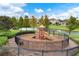 A community playground with slides, climbing areas, a bench, black metal fence, and landscaping at 448 Douglas Edward Dr, Ocoee, FL 34761