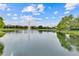 Scenic community pond view featuring a fountain, established lawn, mature trees and neighborhood homes at 448 Douglas Edward Dr, Ocoee, FL 34761