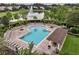 Aerial view of a sparkling community pool surrounded by lounge seating, bath house, and lake at 448 Douglas Edward Dr, Ocoee, FL 34761