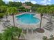 Aerial view of a community pool featuring lounge chairs, bath house, and palm trees at 448 Douglas Edward Dr, Ocoee, FL 34761