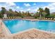 Community swimming pool with clear blue water, brick paver decking, lounge chairs and views of the playground and neighborhood at 448 Douglas Edward Dr, Ocoee, FL 34761