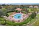 Aerial view of a community pool featuring lounge chairs, pergola, palm trees, bath house, and playground at 448 Douglas Edward Dr, Ocoee, FL 34761