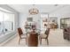 Dining room featuring a glass table, wood chairs, and adjacent open-concept living spaces at 465 Mandalay Rd, Orlando, FL 32809