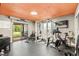 This home gym includes gym equipment and a sliding glass door leading to the patio at 465 Mandalay Rd, Orlando, FL 32809