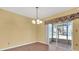 Sunny dining room with tile flooring, chandelier, and sliding glass door to the screened lanai at 4801 Coachmans Dr # 2, Orlando, FL 32812