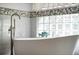 Close-up of a modern tub with decorative fish and a window with glass blocks at 5219 Hammock Cir, St Cloud, FL 34771