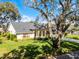 Well-maintained front yard with mature landscaping surrounding a beautiful home shaded by a large tree at 5219 Hammock Cir, St Cloud, FL 34771