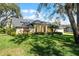 Well-maintained front yard showcasing a charming home with a lush lawn and mature trees at 5219 Hammock Cir, St Cloud, FL 34771