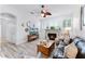 Cozy living room with hardwood floors, a fireplace, a ceiling fan, and ample natural light at 5219 Hammock Cir, St Cloud, FL 34771