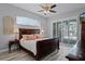 Well-lit main bedroom with elegant dark wood furniture, decorative glass window, and a ceiling fan at 5219 Hammock Cir, St Cloud, FL 34771