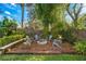 Secluded backyard retreat with a charming stone fire pit and Adirondack chairs amidst lush bamboo at 533 Balmoral Rd, Winter Park, FL 32789