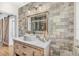 Bathroom featuring a vessel sink on a stone countertop, decorative mirror, and accent wall at 533 Balmoral Rd, Winter Park, FL 32789