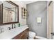 Simple bathroom featuring a wooden vanity, toilet, and tiled shower with glass door at 533 Balmoral Rd, Winter Park, FL 32789