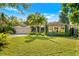 Lovely single-story home featuring a well-manicured lawn, palm trees, and a paved driveway at 533 Balmoral Rd, Winter Park, FL 32789