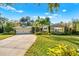 Charming single-story home featuring a well-manicured lawn, palm trees, and a paved driveway at 533 Balmoral Rd, Winter Park, FL 32789