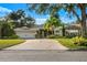 Appealing single-story home featuring a well-manicured lawn, palm trees, and a paved driveway at 533 Balmoral Rd, Winter Park, FL 32789