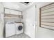 Well-lit laundry room with washer, dryer, overhead shelving and door at 533 Balmoral Rd, Winter Park, FL 32789