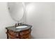 Powder room features antique vanity, patterned bowl sink, decorative faucet, and large oval mirror at 5361 Tortuga Dr, Orlando, FL 32837