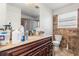 Bathroom with a toilet and a dark wood vanity with sink and beautiful tiling at 5361 Tortuga Dr, Orlando, FL 32837