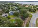 An aerial shot of a home with a tennis court, pool, and lake view at 644 Strihal Loop, Oakland, FL 34787