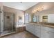 Luxurious bathroom with a glass-enclosed shower, soaking tub, double vanity, and neutral-toned tile at 644 Strihal Loop, Oakland, FL 34787