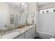 Bathroom featuring dual sinks with granite countertop, white cabinets, and a shower-tub combo at 644 Strihal Loop, Oakland, FL 34787