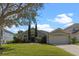 Single-story home features manicured lawn, mature trees, and attached two-car garage with curb appeal at 644 Strihal Loop, Oakland, FL 34787