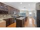 Spacious kitchen with dark wood cabinetry, granite countertops, and stainless steel appliances at 644 Strihal Loop, Oakland, FL 34787